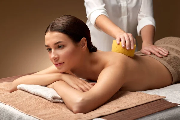 Kvinna som har ryggmassage med svamp på spa — Stockfoto