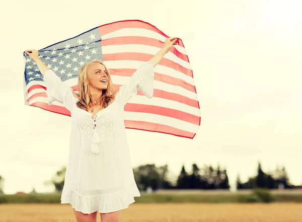 Mujer feliz con bandera americana en el campo de cereales — Foto de Stock