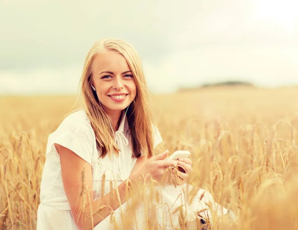 Mujer feliz con smartphone y auriculares — Foto de Stock