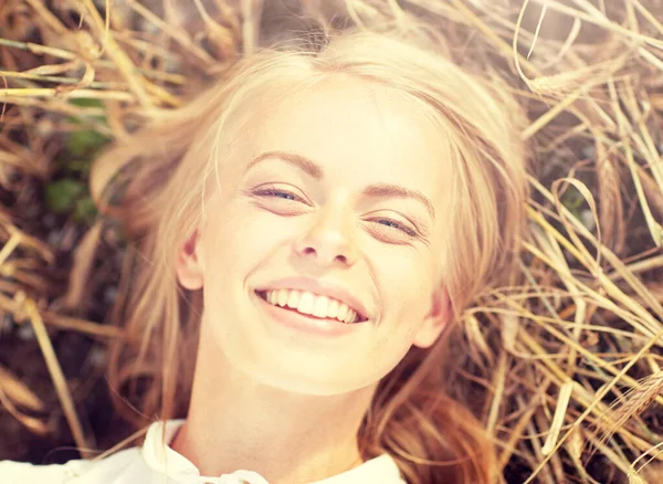 Happy young woman lying on cereal field — Stock Photo, Image