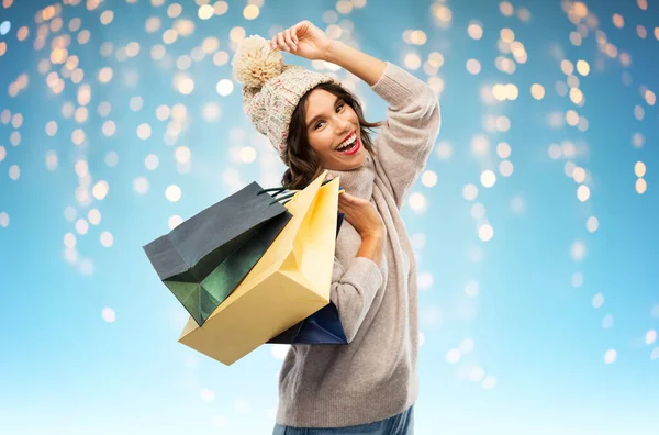 Jovem mulher no chapéu de inverno com sacos de compras — Fotografia de Stock