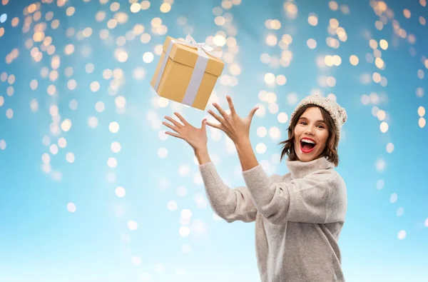 Jonge vrouw in de winter hoed vangen geschenk doos — Stockfoto