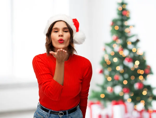 Gelukkig jong vrouw in santa hoed verzenden lucht kus — Stockfoto