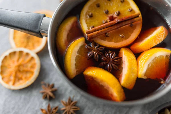 Olla con vino caliente caliente, rodajas de naranja y especias — Foto de Stock