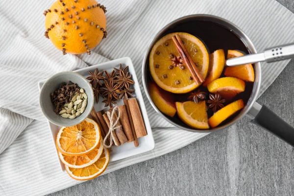 Pentola con vin brulè caldo, fette di arancia e spezie — Foto Stock