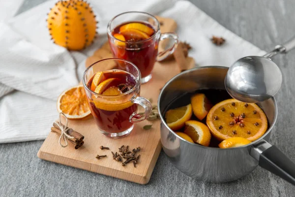 Pentola con vin brulè caldo, fette di arancia e spezie — Foto Stock