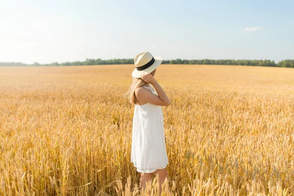 Porträtt av flicka i halmhatt på fältet på sommaren — Stockfoto