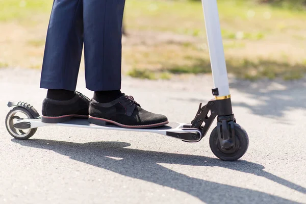 Ung affärsman med elektrisk skoter utomhus — Stockfoto