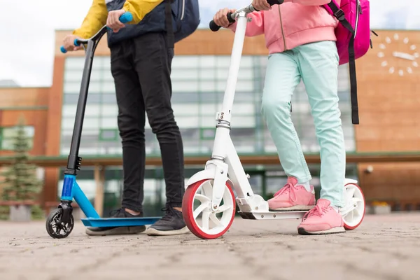 Schoolkinderen met rugzakken en scooters — Stockfoto