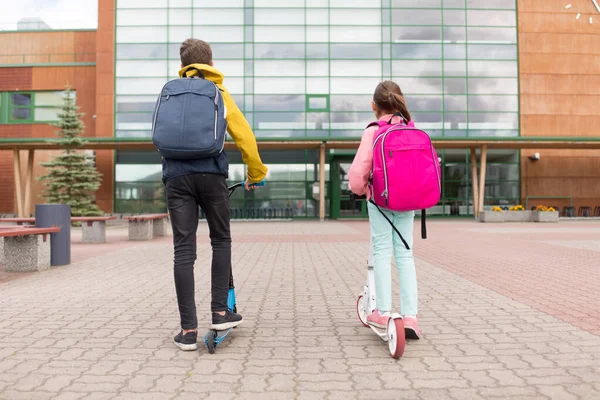 Sırt çantalı ve scooterlı okul çocukları — Stok fotoğraf