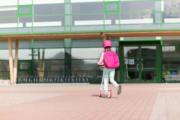 Gadis sekolah dengan tas punggung naik skuter — Stok Foto