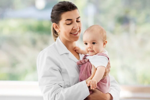 Female pediatrician doctor with baby at clinic — Stock Photo, Image