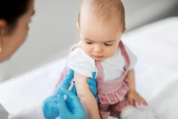 Врач делает вакцину для ребенка пациента в клинике — стоковое фото
