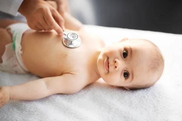 Orvos sztetoszkóppal hallgatja a baba beteg — Stock Fotó