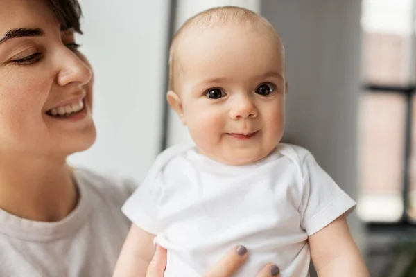 Lycklig ung mor håller liten baby dotter — Stockfoto