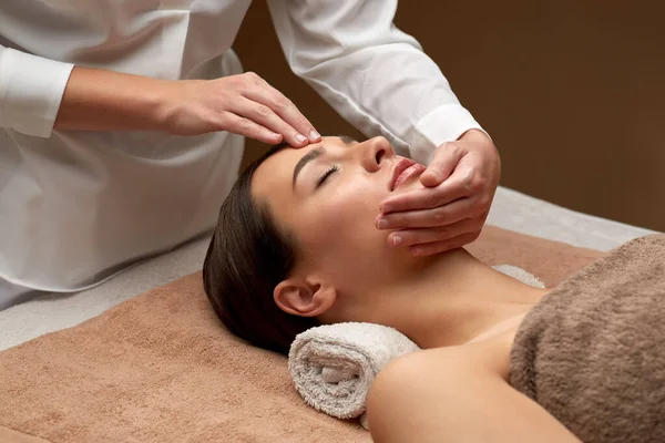 Жінка має масаж обличчя та голови у спа-центрі — стокове фото