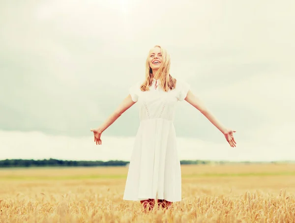 Sonriente joven en vestido blanco en el campo de cereales — Foto de Stock