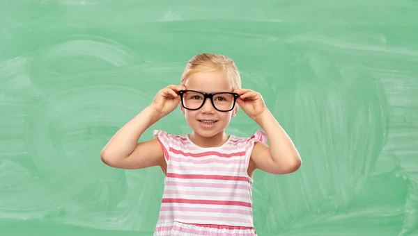 Χαμογελαστό χαριτωμένο κοριτσάκι με γυαλιά στο σχολείο — Φωτογραφία Αρχείου