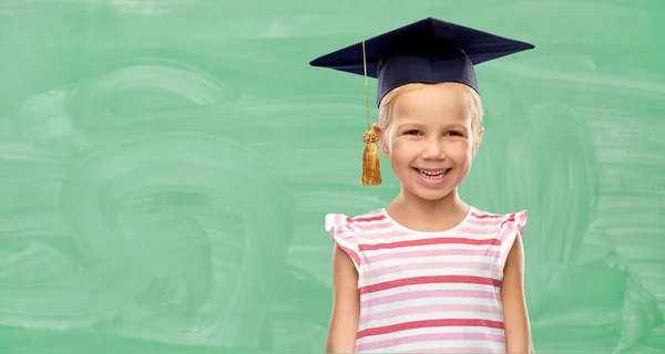 Felice ragazza della scuola in cappello da scapolo o mortarboard — Foto Stock
