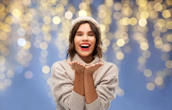 Kvinna i vinter hatt skicka luft kyss på jul — Stockfoto