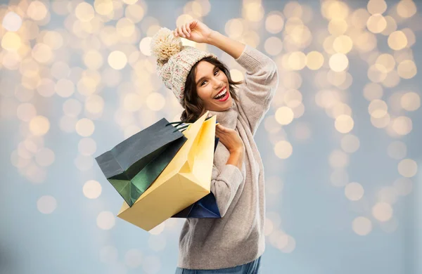 Young woman in winter hat with shopping bags — Stock Photo, Image