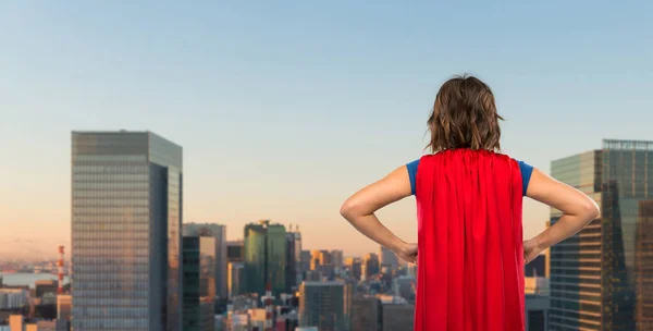 Mulher em capa de super-herói vermelho sobre a cidade de tokyo — Fotografia de Stock