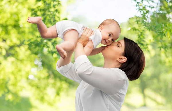 Mãe feliz beijando filhinha bebê — Fotografia de Stock