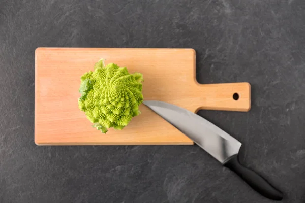 Brócolis romanesco e faca na placa de corte — Fotografia de Stock
