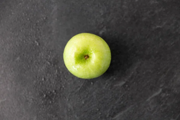 Ripe green apple on slate stone background — Stock Photo, Image