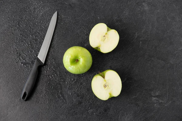 Zielone jabłka i nóż kuchenny na tle łupków — Zdjęcie stockowe