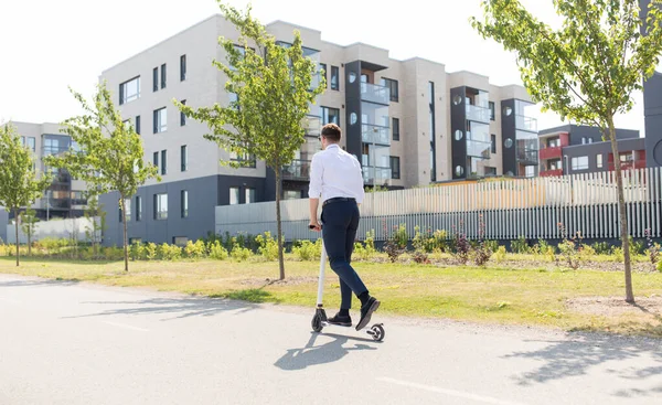 Ung forretningsmann som kjører elektrisk scooter utendørs – stockfoto