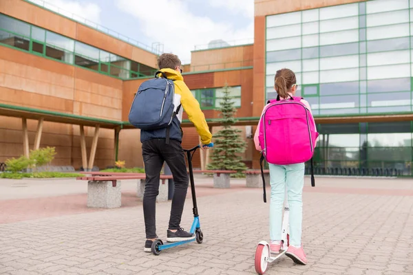 Schoolkinderen met rugzakken en scooters — Stockfoto