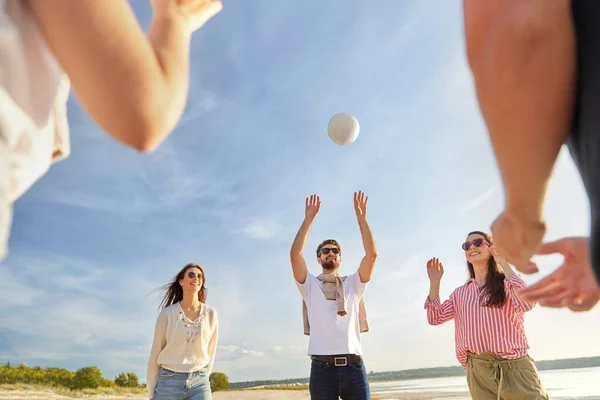 Друзья играют в волейбол на пляже летом — стоковое фото