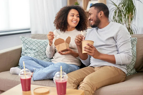 Happy couple with takeaway food and drinks at home — Stock Photo, Image