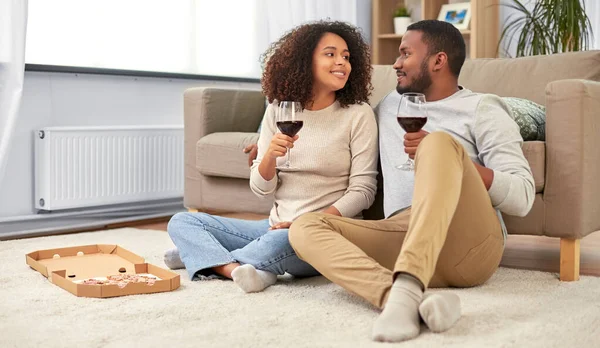 Ευτυχισμένο ζευγάρι με κρασί και πίτσα σε πακέτο στο σπίτι — Φωτογραφία Αρχείου