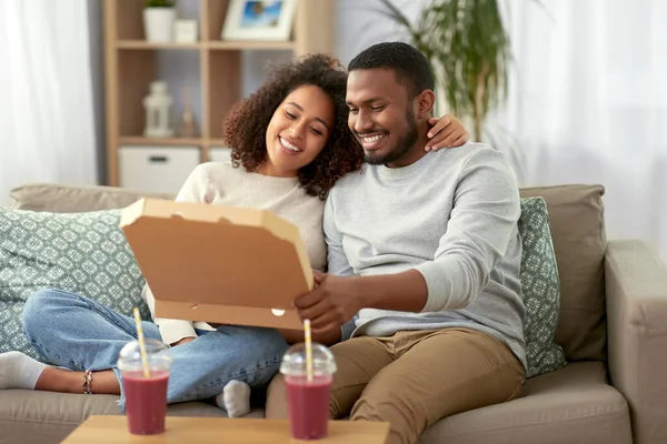 Happy african american couple eating pizza at home — Stock Photo, Image