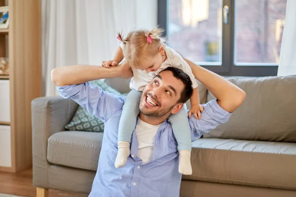 Padre cabalgando pequeño bebé hija en el cuello en casa —  Fotos de Stock