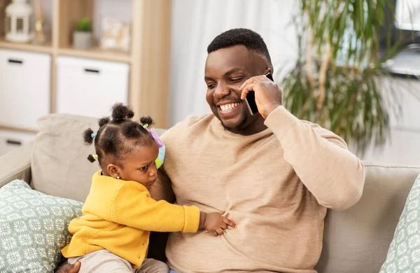 Батько з дитиною вдома дзвонить на смартфон — стокове фото