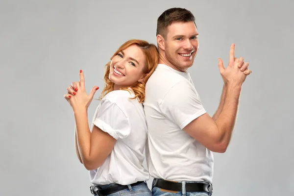 Paar in witte t-shirts shirts maken pistool gebaar — Stockfoto