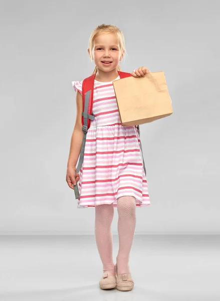 Little student girl with school lunch in paper bag — Stock Photo, Image