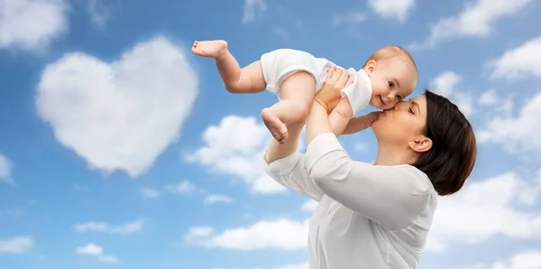 Счастливая мать целует маленькую дочку — стоковое фото