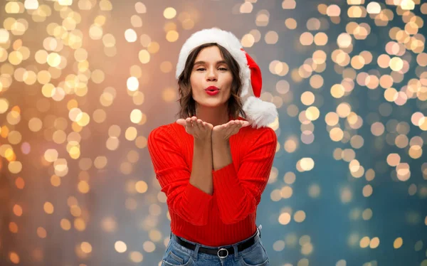Щаслива молода жінка в капелюсі Санта відправляє повітряний поцілунок — стокове фото