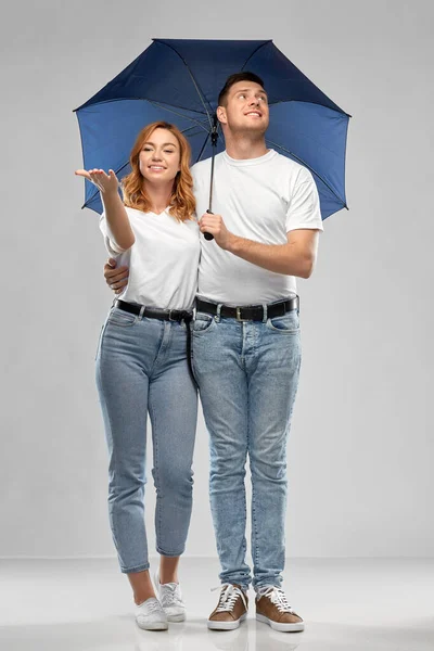 Szczęśliwa para w białych koszulkach z parasolem — Zdjęcie stockowe