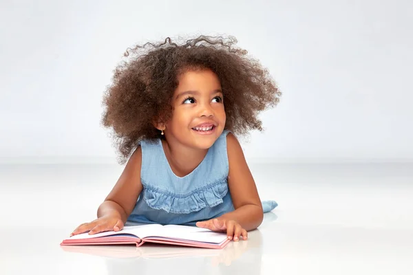 Uśmiechnięta dziewczynka african american czytanie książki — Zdjęcie stockowe