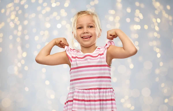 Glimlachend klein meisje tonen haar kracht — Stockfoto