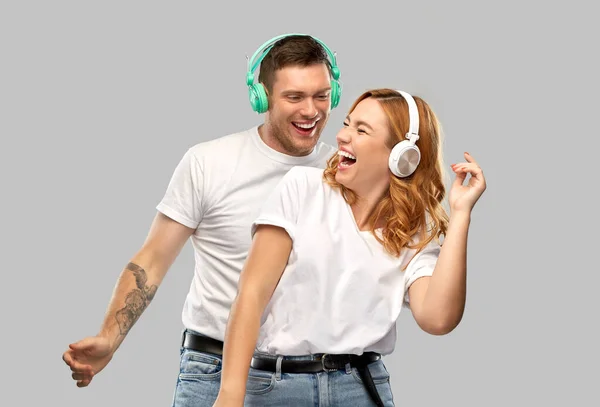 Feliz pareja en auriculares bailando — Foto de Stock