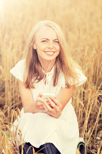 Gelukkige vrouw met smartphone en oortelefoons — Stockfoto