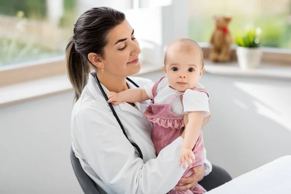 Vrouwelijke kinderarts arts met baby in kliniek — Stockfoto