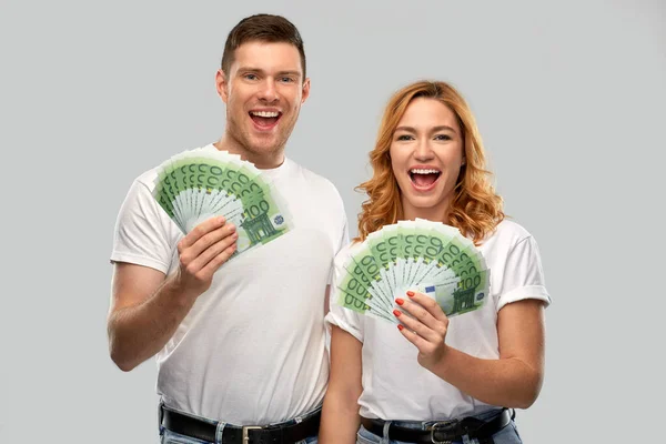 Casal feliz em camisetas brancas com dinheiro euro — Fotografia de Stock