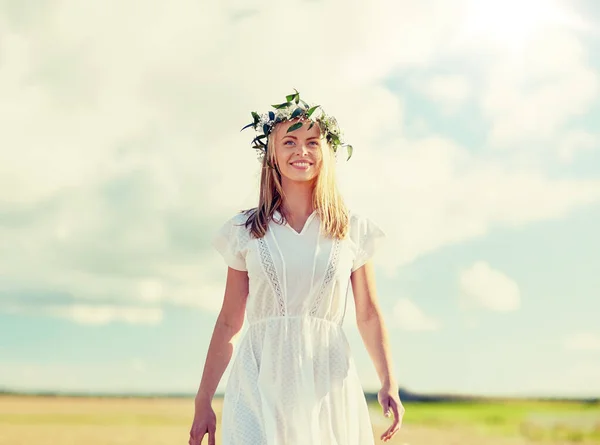 Jonge vrouw in een krans van bloemen buiten glimlachen — Stockfoto